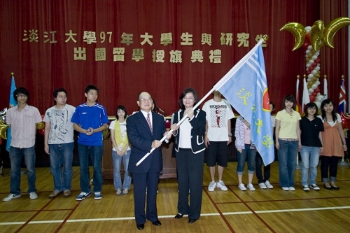 97學年度在校生出國授旗典禮在淡水校園學生活動中心舉行，張創辦人建邦、張校長家宜親臨授旗，各國駐華使節也親臨會場，為這群即將到實地環境學習多元文化與語言、累積生命能量的出國留學生加油打氣。