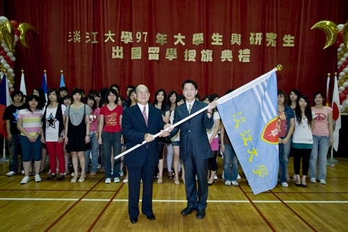 97學年度在校生出國授旗典禮在淡水校園學生活動中心舉行，張創辦人建邦、張校長家宜親臨授旗，各國駐華使節也親臨會場，為這群即將到實地環境學習多元文化與語言、累積生命能量的出國留學生加油打氣。