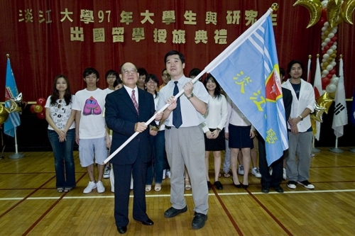 97學年度在校生出國授旗典禮在淡水校園學生活動中心舉行，張創辦人建邦、張校長家宜親臨授旗，各國駐華使節也親臨會場，為這群即將到實地環境學習多元文化與語言、累積生命能量的出國留學生加油打氣。