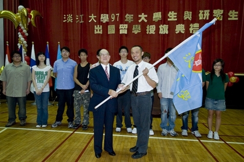 97學年度在校生出國授旗典禮在淡水校園學生活動中心舉行，張創辦人建邦、張校長家宜親臨授旗，各國駐華使節也親臨會場，為這群即將到實地環境學習多元文化與語言、累積生命能量的出國留學生加油打氣。